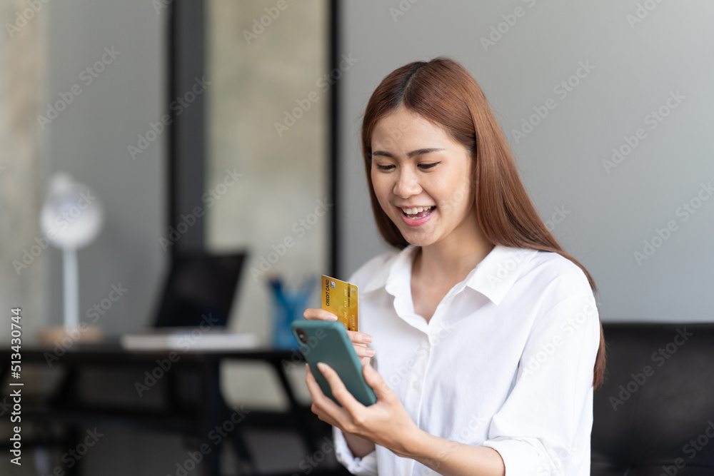 Young woman holding credit card and using smartphone, online payment concept. Young woman holding credit card and using smartphone, online payment concept.