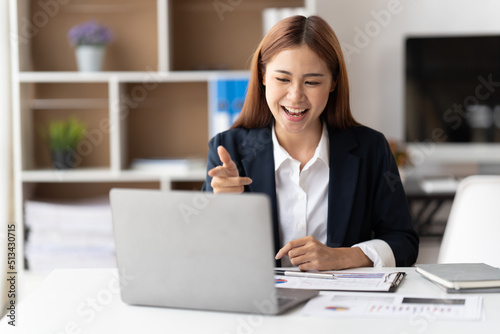 Young attractive business asian woman talking about sale report in video call conference on notebook computer online meeting in working from home.