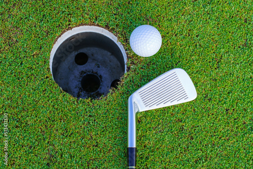 Golf ball and golf club in beautiful golf course at Thailand. golf equipment resting on green grass background