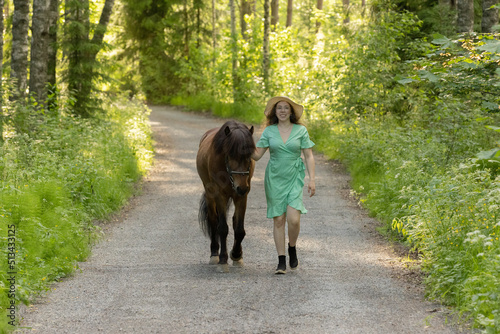 Icelandic horse on gravel road with young woman. Shot in the evening middle of the summersummer in Finland © AnttiJussi