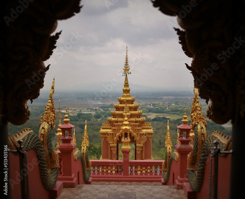 Picture of the top of a pagoda on a mountain taken through a window.