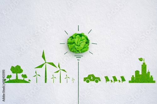 Green crumpled paper light bulb on white paper background, eco-friendly business and environmental concept photo