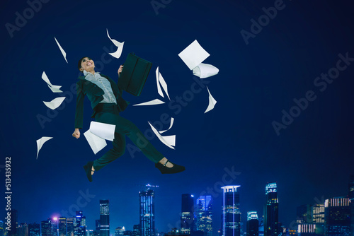 Happy businesswoman jump with papers in night city