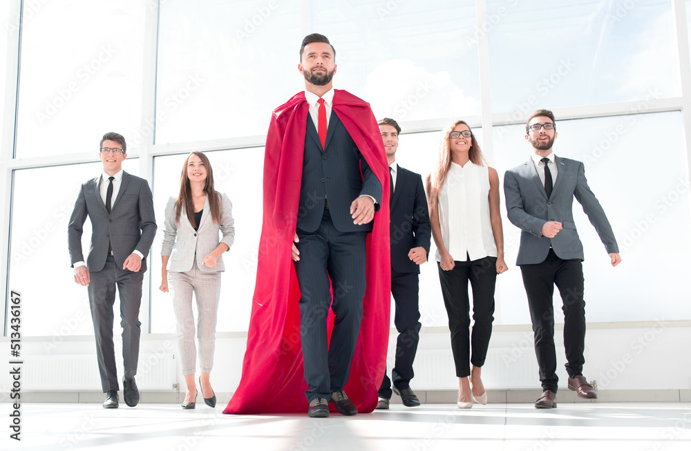 businessman-superhero and business team standing in the office.
