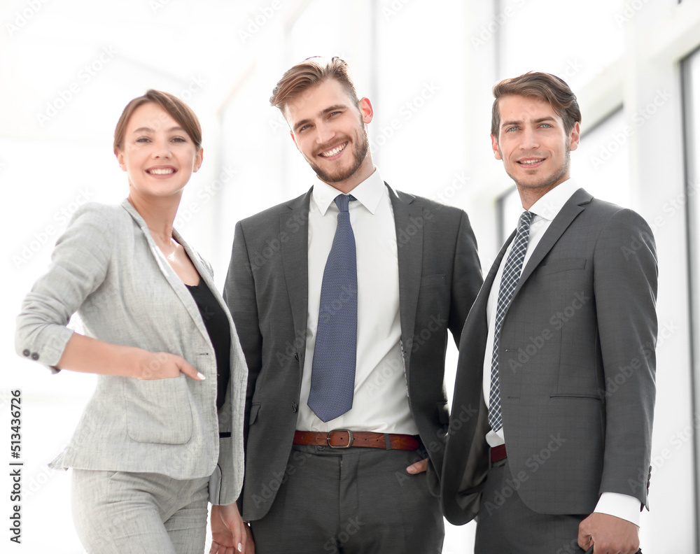 three business colleagues standing in a bright office three business colleagues standing in a bright office