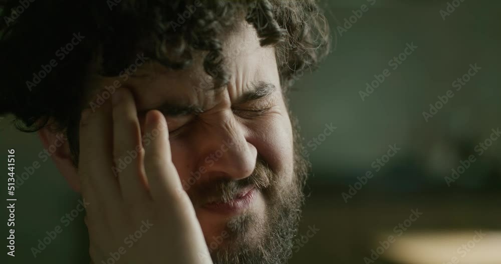 Portrait of a young bearded man with a headache. Close up. Portrait of a young bearded man with a headache. Close up.