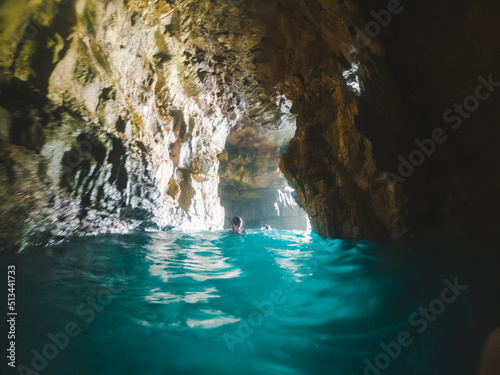 woman swimming with snorkeling mask in sea grotto cave photo