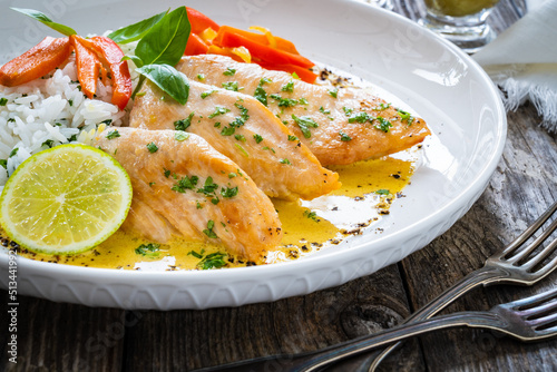 Fried chicken breasts in curry sauce with white rice on wooden table 