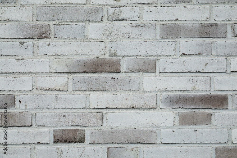 Fototapeta premium White brick wall background with cracked and rough surface of the stones, no person 