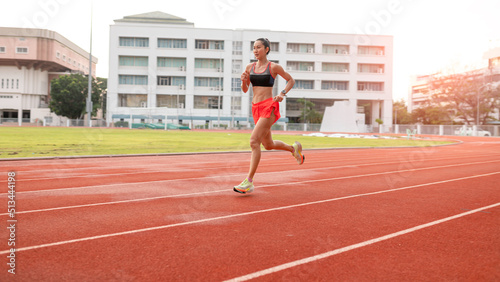 woman running during sunny morning on stadium track
