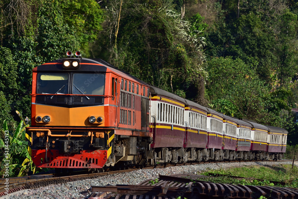 Thai passenger train by diesel locomotive on the railway.