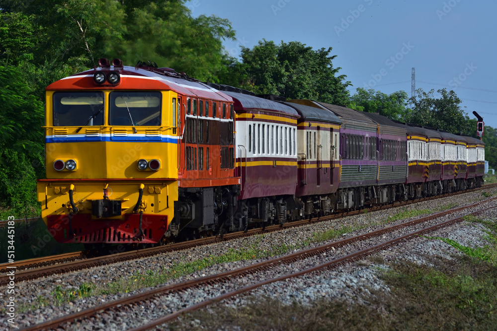 Thai passenger train by diesel locomotive on the railway.