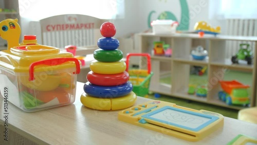 Wallpaper Mural Colorful plastic pyramid and different toys on wooden shelf in kindergarten playroom closeup. Little children development Torontodigital.ca