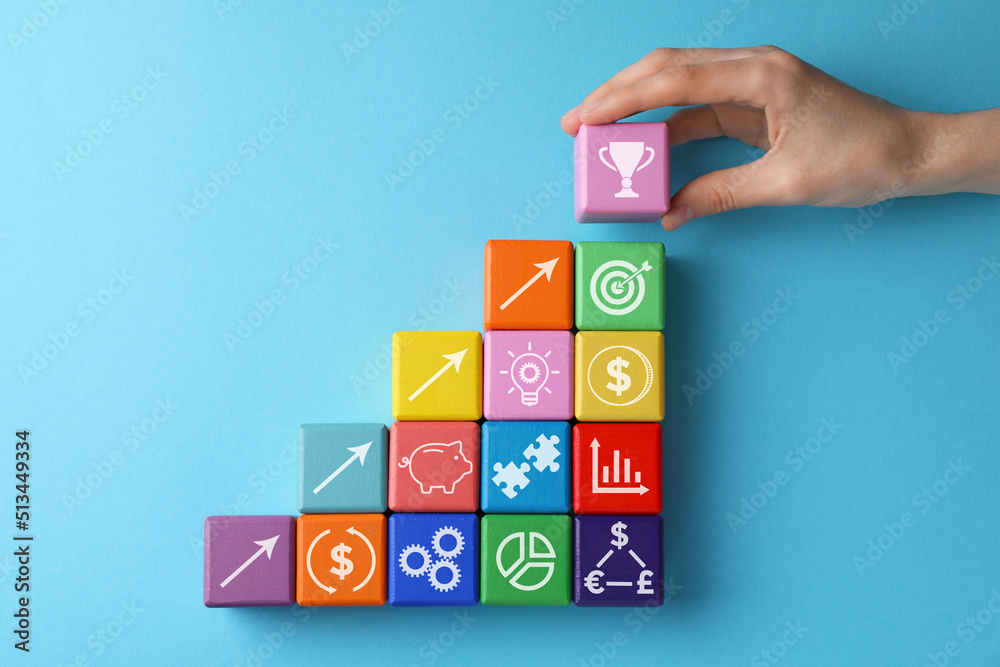 Top view of woman and colorful cubes with different images on light blue background