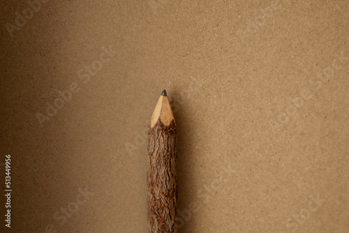 Top view or flat lay Old fashioned or classic style pencil made of nature real wood from trees and toxin free on light brown notebook cover or cardboard box paper texture background and space photo