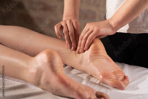 Close-up of female hands doing foot massage in spa