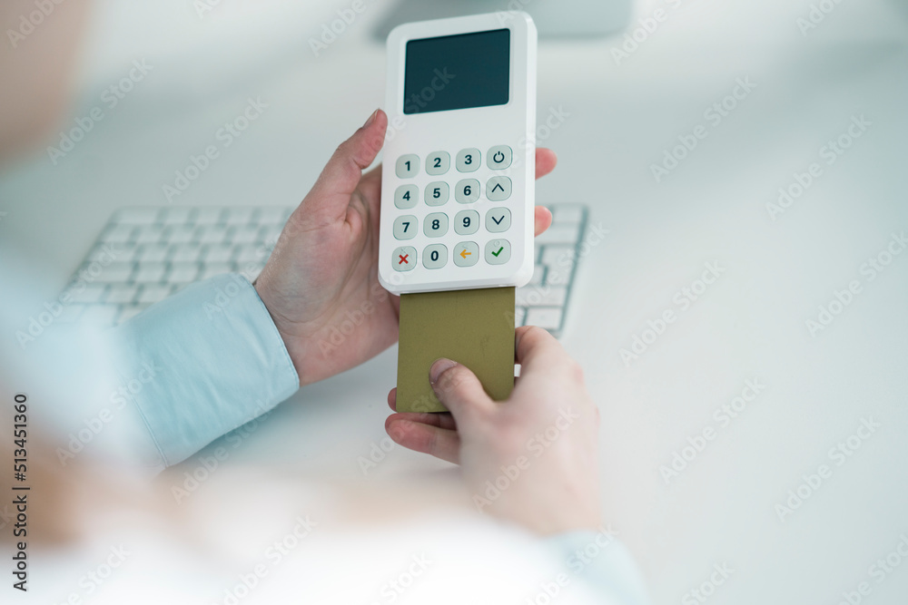 Hands of woman paying through credit card at office Hands of woman paying through credit card at office