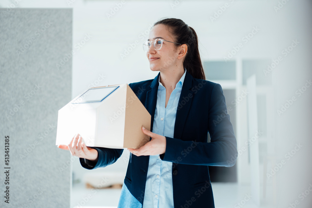 Smiling businesswoman with solar panel on model house at work place Smiling businesswoman with solar panel on model house at work place