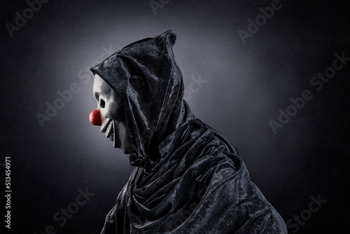 Fototapeta Scary clown showing his teeth over dark misty background