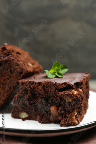 Delicious brownies with nuts and mint on table, closeup. Space for text