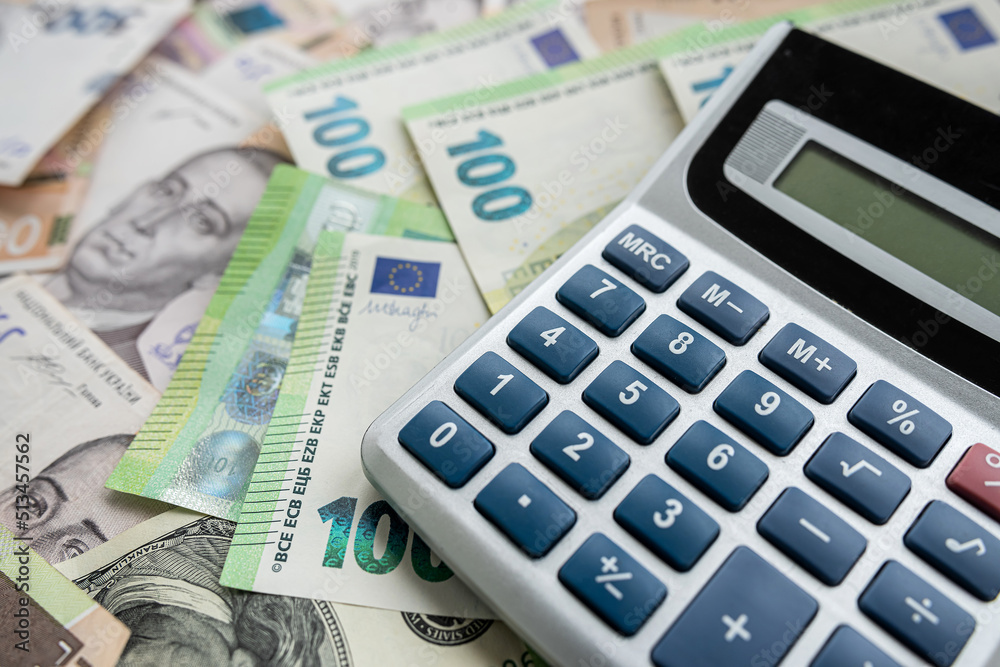 euro and hryvnia are scattered around table with a calculator to determine the exchange rate. euro and hryvnia are scattered around table with a calculator to determine the exchange rate.