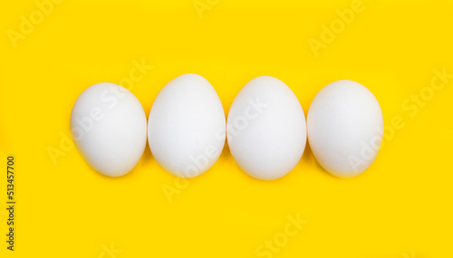 white chicken egg isolated on yellow background.