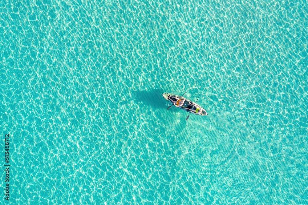 Fototapeta premium Summer vacation fun, sport activity. Men on Canoe kayak in turquoise blue Aegean Sea, aerial view.