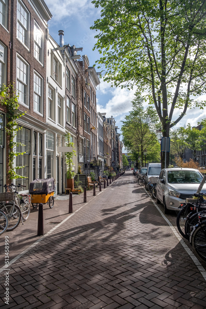 Amsterdam city paved sidewalk. Traditional house, bike parked in front, Holland Netherlands.