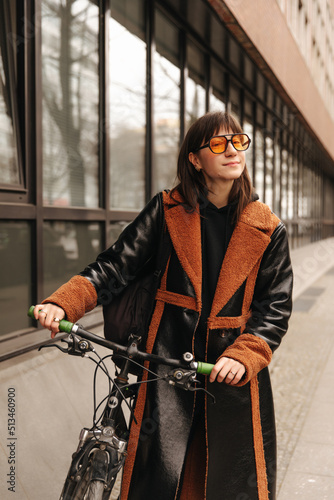 Full view of smiling woman in sunglasses with bike look at camera 