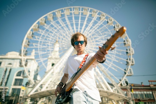 Young man playing the guitar on a street.