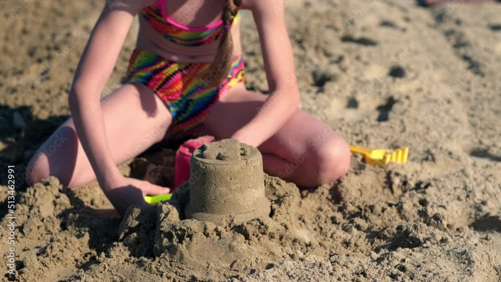 Little girl playing with sand on beach ocean sea. Childhood ... 