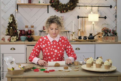 Fotografie sad woman in a red dress with polka dots cooks in the kitchen
