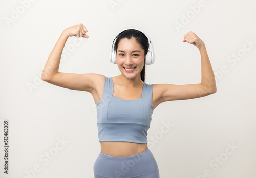 Sexy sporty fitness asian woman with sportswear put on headphone isolated white background. Portrait Good shape and healthy woman standing pose exercise workout in studio.