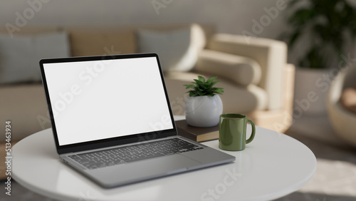 Portable notebook laptop mockup on coffee table in modern comfortable living room.