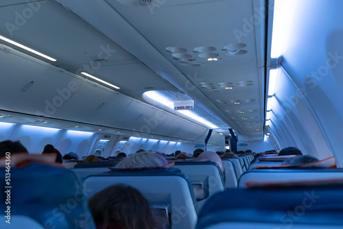 The cabin of the plane with passengers in their seats before takeoff. Public place. Selective focus. Close-up
