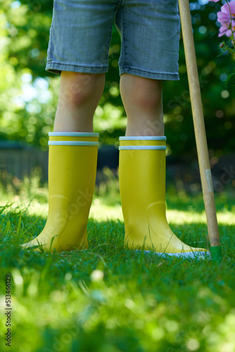 Gelbe Gummistiefel Kinder Garten mit Gießkanne und Harke  photo