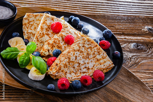 A plate of pancakes with cheese and fruits photo