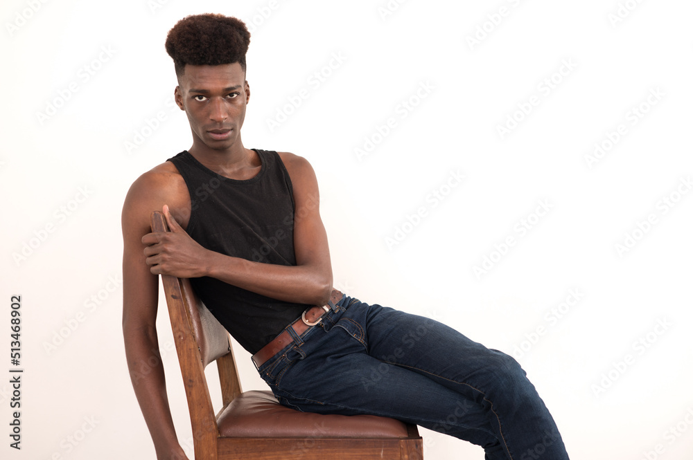 Portrait of handsome young man seen sitting on chair