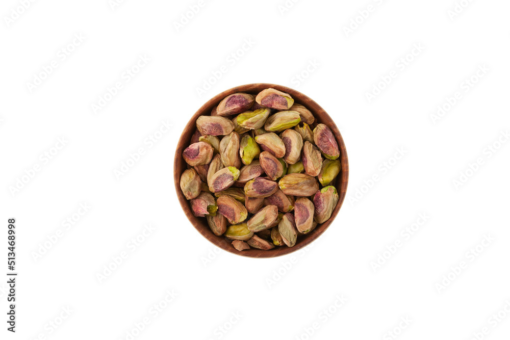 Peeled pistachios in wooden bowl on white background, top view. Green pistachio Peeled pistachios in wooden bowl on white background, top view. Green pistachio