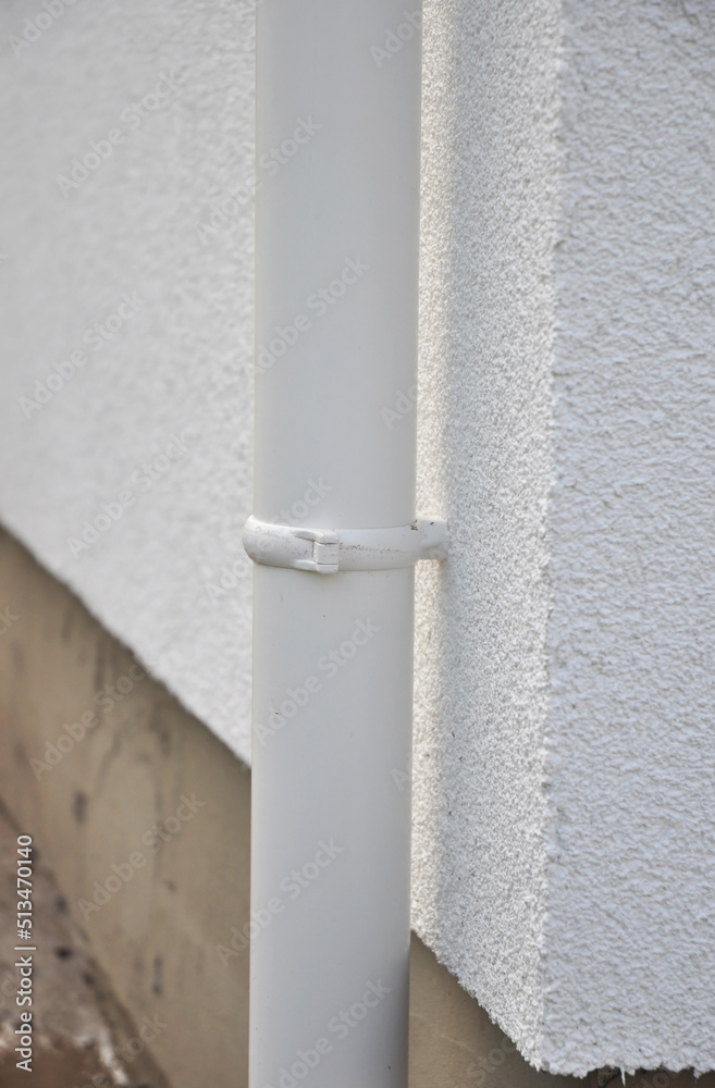 Close up on roof gutter downspout pipe holder on the house facade wall. Close up on roof gutter downspout pipe holder on the house facade wall.