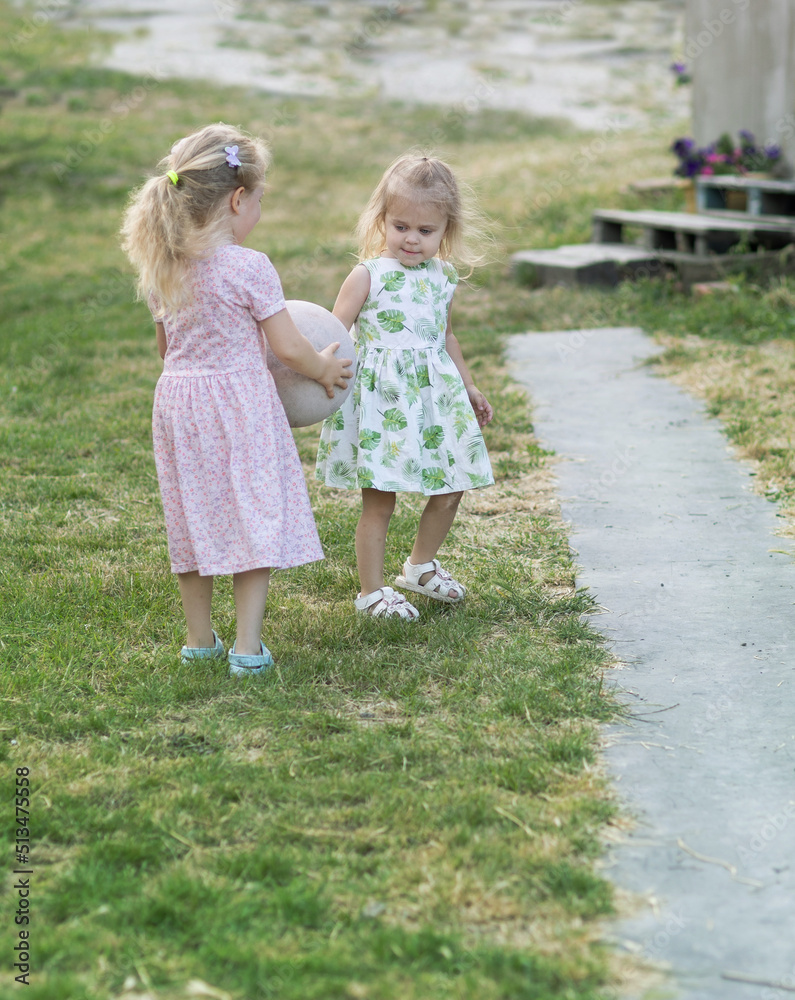 Two girls play in the yard of the house Two girls play in the yard of the house