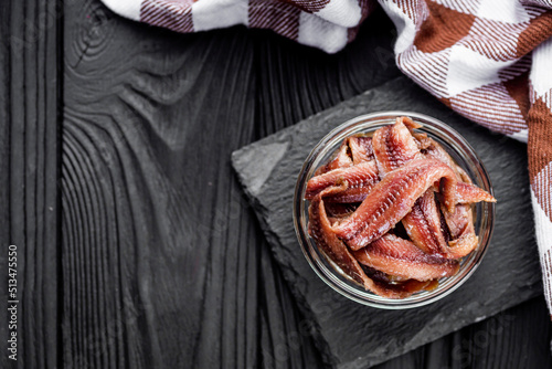 canned anchovy fillet on a black wooden rustic background photo