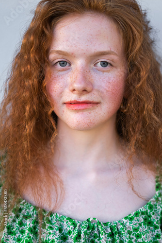 Close up freckled curly girl smiling. Natural beauty young cheerful redheared woman photo