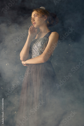 the port of a beautiful, sophisticated woman in a long evening dress, posing relaxed in a smoky room © Lina Solntseva 