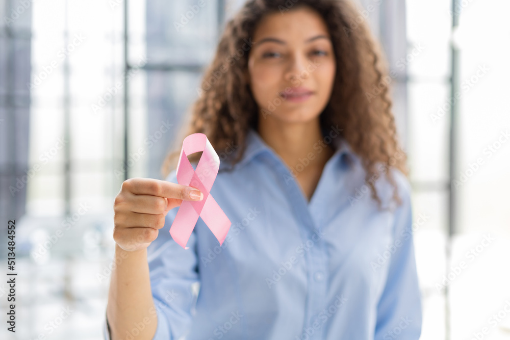 October breast cancer awareness month, woman with hand holding pink ribbon for supporting people living and illness. Healthcare, world cancer day concept. October breast cancer awareness month, woman with hand holding pink ribbon for supporting people living and illness. Healthcare, world cancer day concept.
