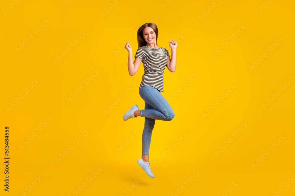 Full length photo of astonished satisfied person jump raise fists triumph luck isolated on yellow color background