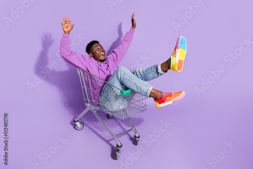 Full length body size view of attractive carefree cheery guy riding cart having fun isolated over vivid violet lilac color background
