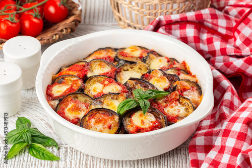 Casserole with homemade baked eggplant Parmigiana di melanzane, made with mozzarella, tomato and basil leaves.