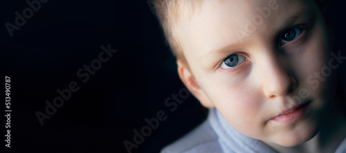 Portrait of a boy in close-up on a dark background