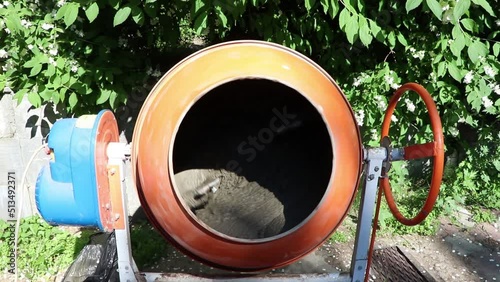 Preparation of cement mortar using a concrete mixer. Construction works. Mixing of mortar for plastering walls